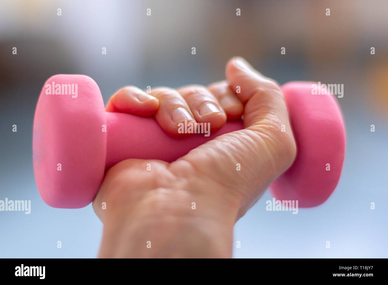 a woman  trains with pink dumb bells Stock Photo