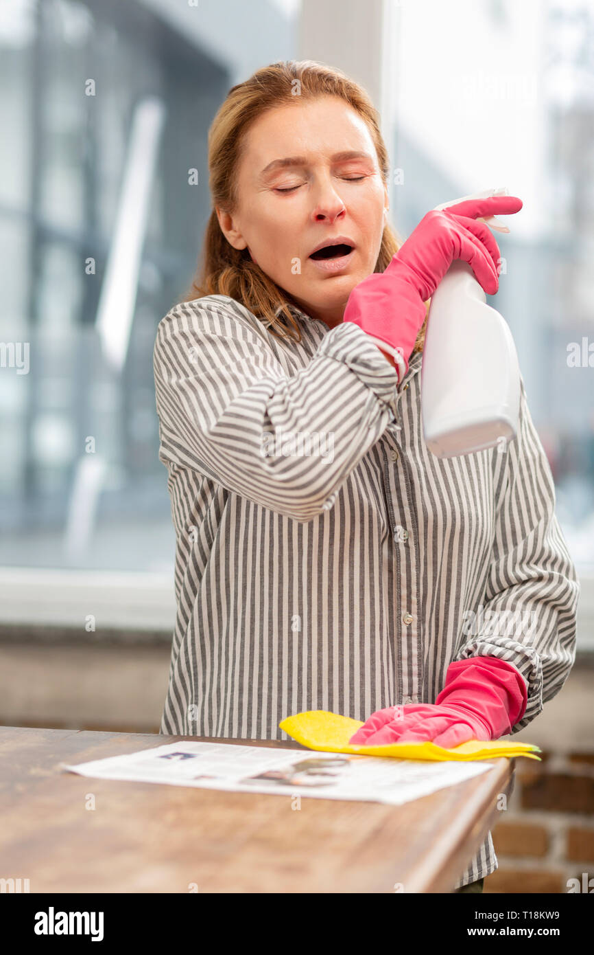 Housewife cleaning kitchen sneezing after using chemicals Stock Photo Alamy