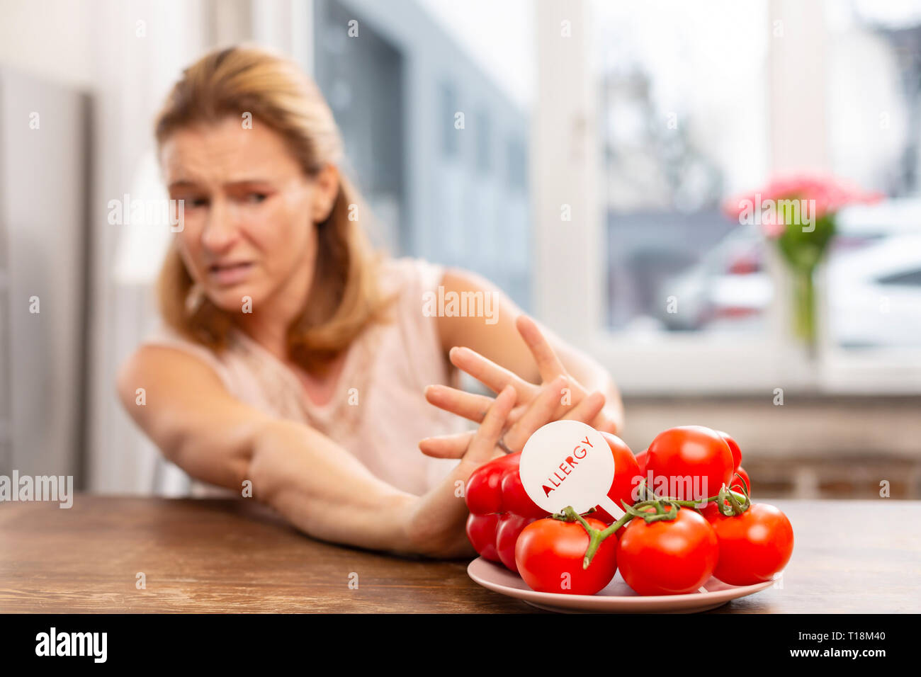 Woman with hypersensitivity to allergens not eating tomatoes Stock Photo
