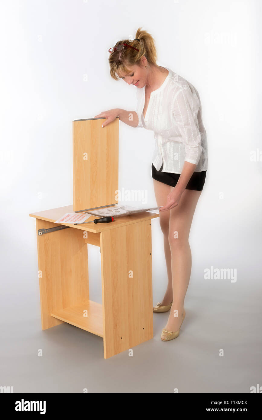Woman Constructing A Personal Computer Desk From A Flatpack Using