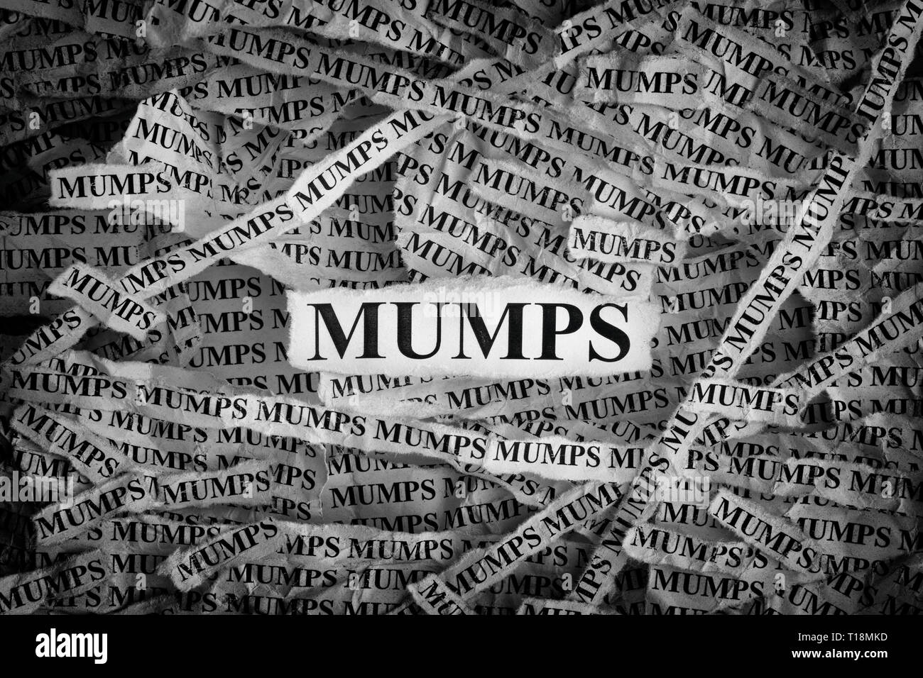 Mumps. Torn pieces of paper with the words Mumps. Concept image. Black and White. Close up. Stock Photo