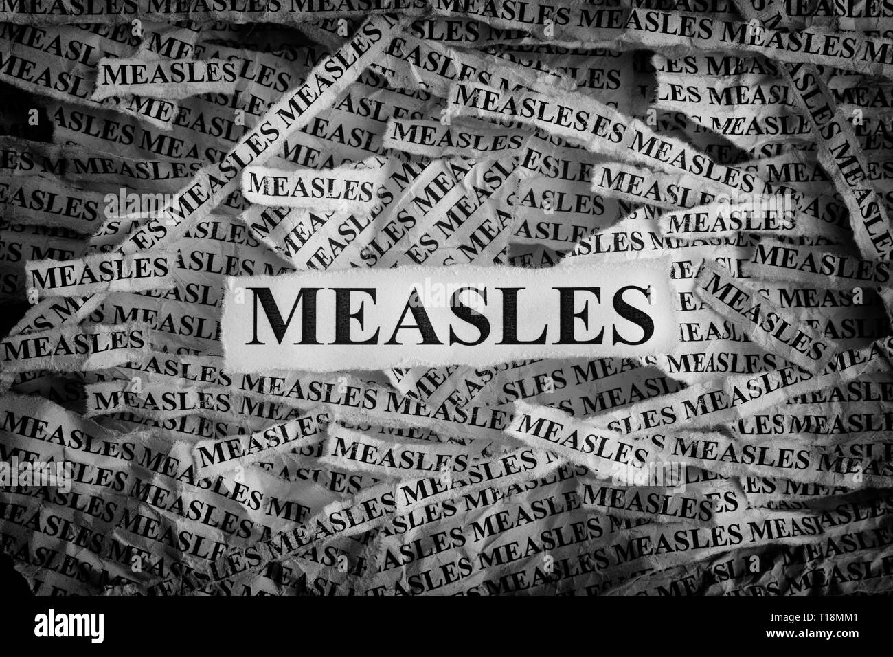 Measles. Torn pieces of paper with the words Measles. Concept image. Black and White. Close up. Stock Photo
