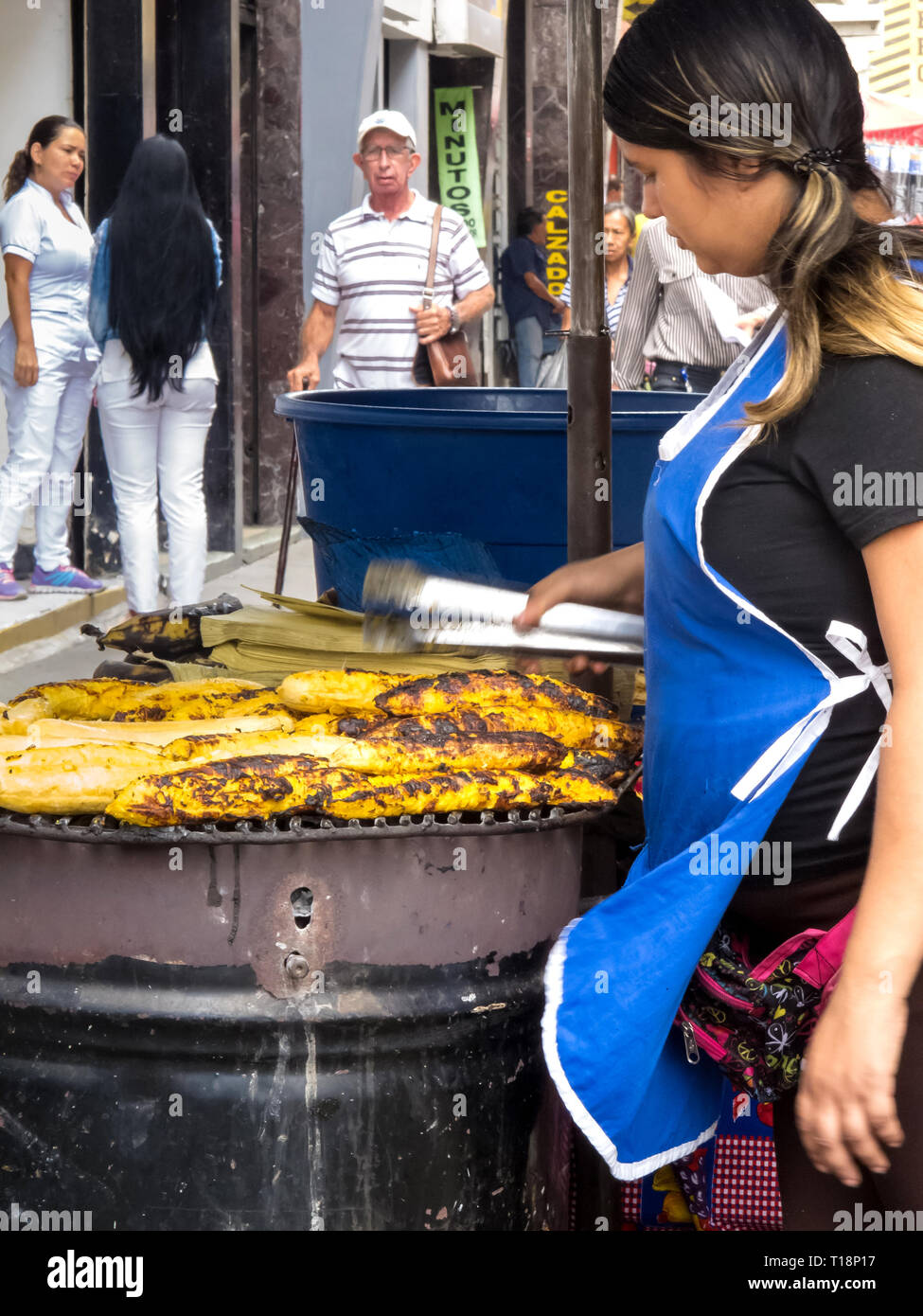 CALI, COLOMBIA - FEBRUARY, 2019: Women cooking and selling roasted ripe plantain at Cali city center Stock Photo