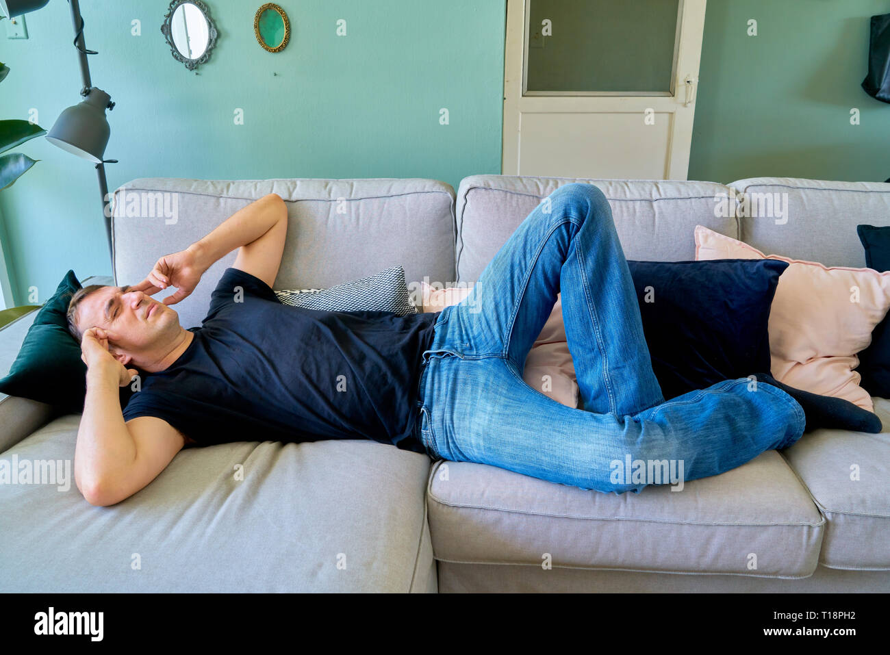 Handsome guy posing lying down, feel sick, headache and suffering