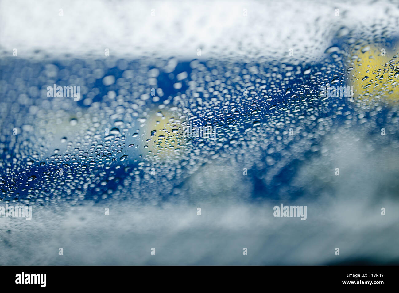 Traffic abstract in rain. Traffic seen from inside a car. Rain drops on windshield and car tail lights in bokeh Stock Photo