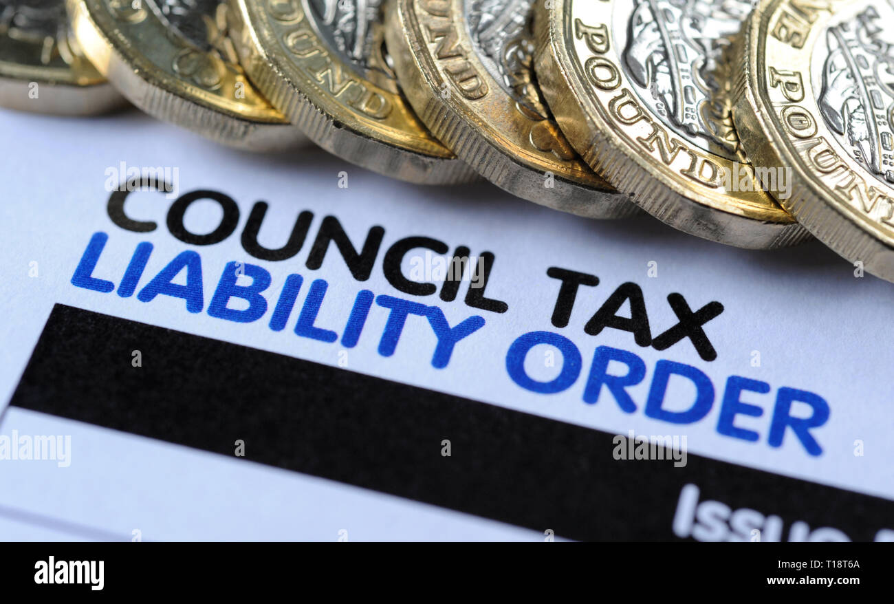 COUNCIL TAX LIABILITY ORDER LETTER WITH ONE POUND COINS RE COUNCILS PAYMENTS BUDGETS HOME OWNERS BILLS ETC UK Stock Photo