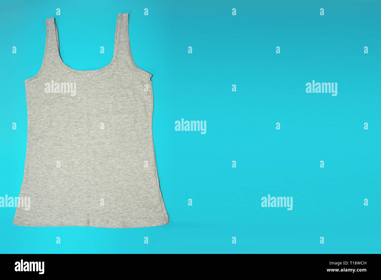 Gray sleeveless female casual tank top on blue background. Copyspace. Sport, fitness aparrel. Basic look. Stock Photo