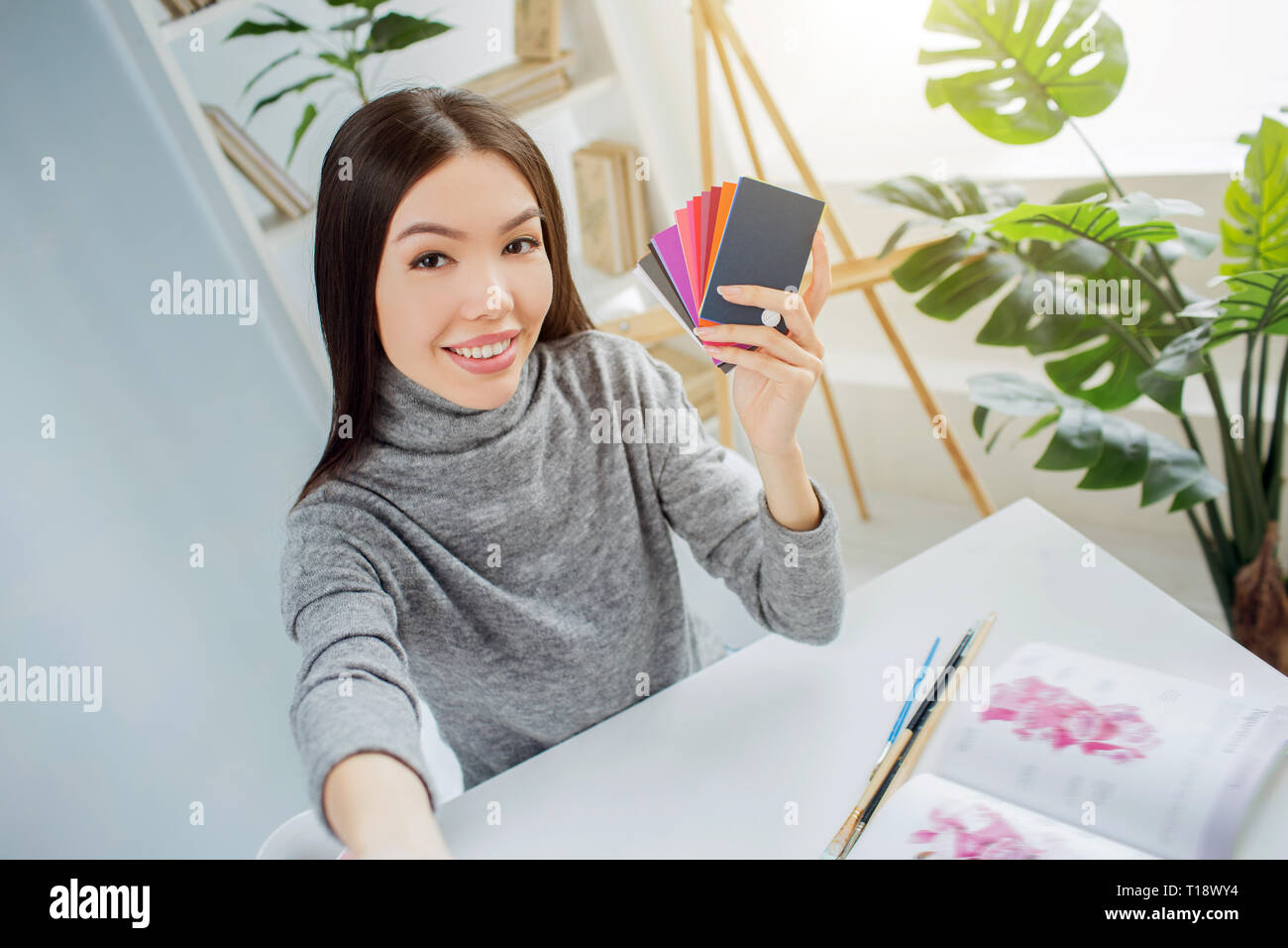 Girl is holding a palette of different colors in her hands. She is ...