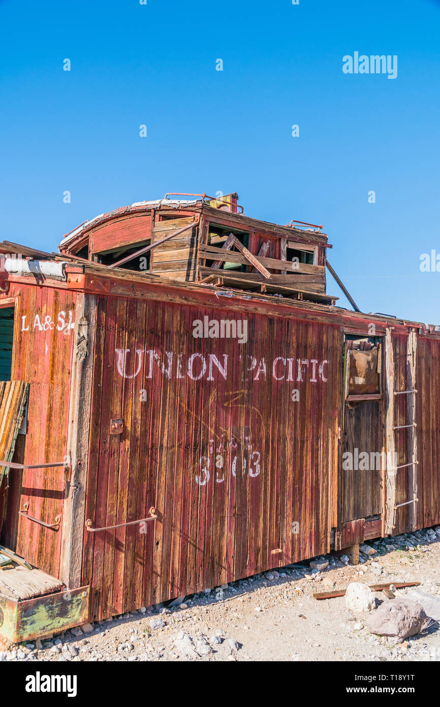 An abandoned, wheelless Union Pacific caboose decaying in the Mojave