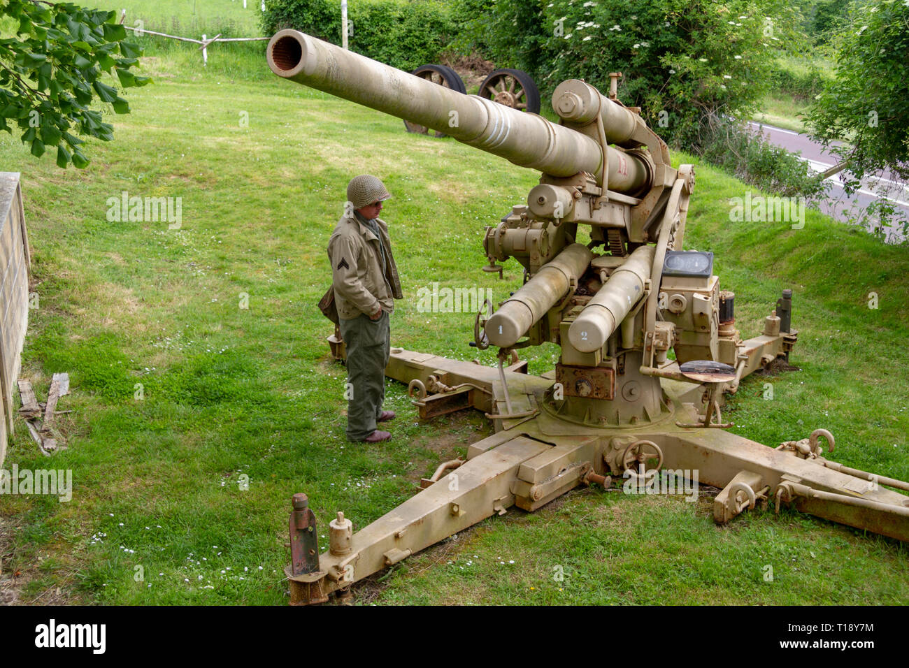 A German FlaK 37 88mm antiaircraft gun, Dead Man's Corner Museum (with a visitor in WWII American uniform, Saint-Côme-du-Mont, Normandy, France. Stock Photo