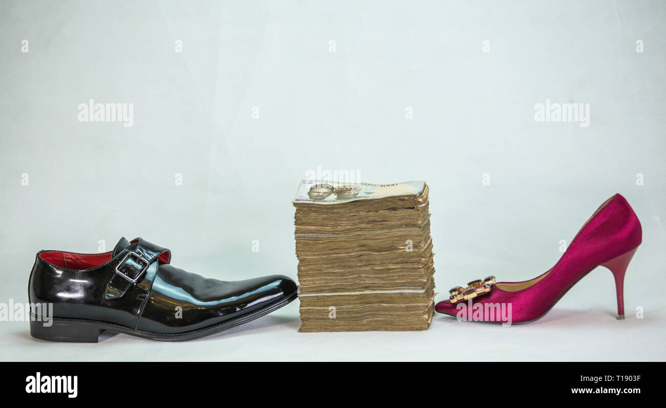 Men shoe and women shoe with bundle of naira notes local currencies cash in white background Stock Photo