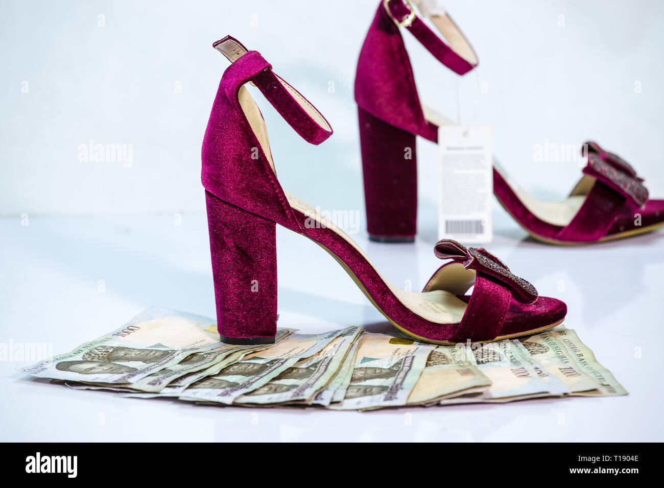 Women shoe with bundle of naira notes local currencies cash in white background Stock Photo