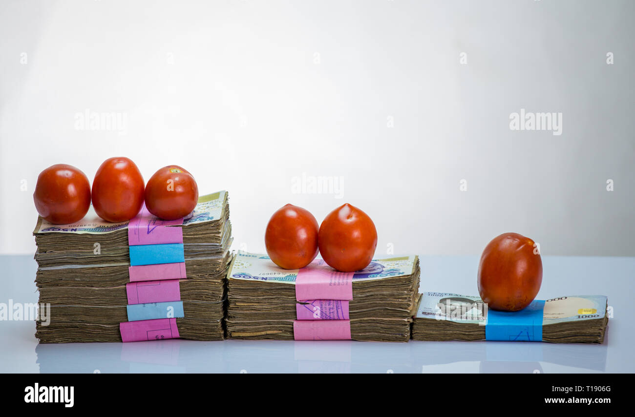 Stack of nigeria naira notes on white background wit tomatoes Stock Photo