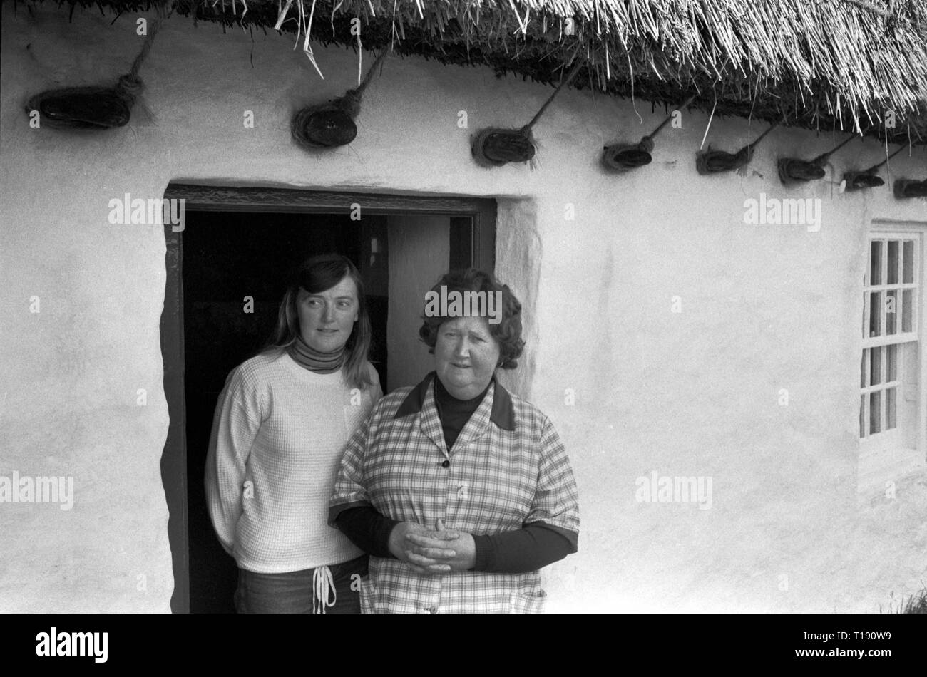 Isle of Man, 1970s. Mother and daughter living in a traditional stone thatched Long House Longhouse 1978. HOMER SYKES Stock Photo