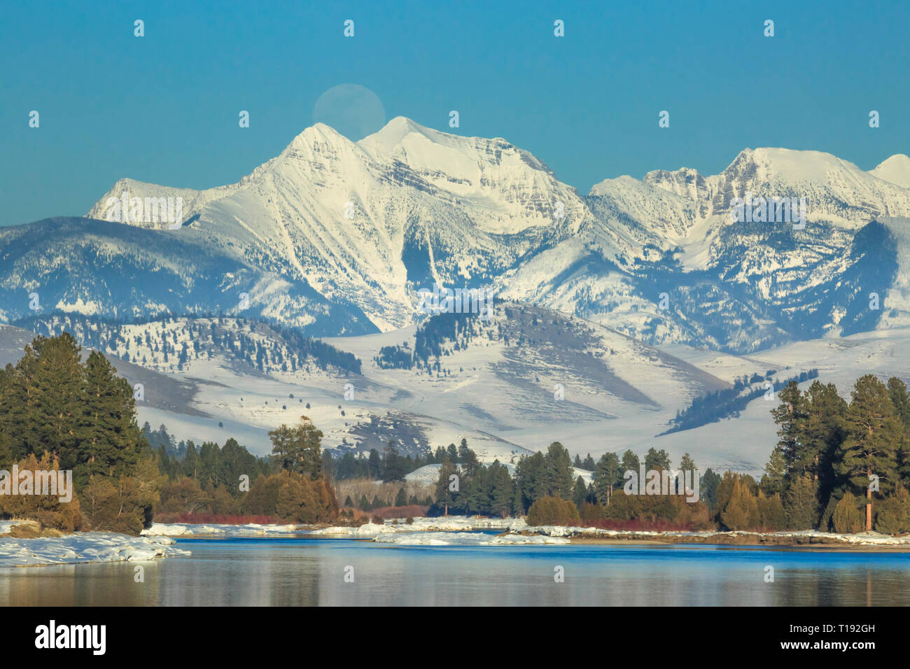 moon rising over the flathead river and mission mountains in winter