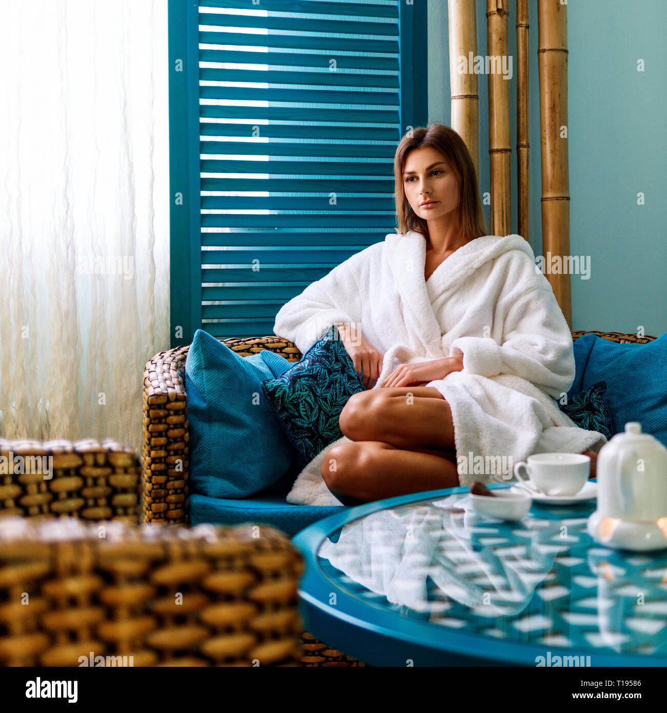 Woman in bathrobe drinking tea in spa salon. Stock Photo