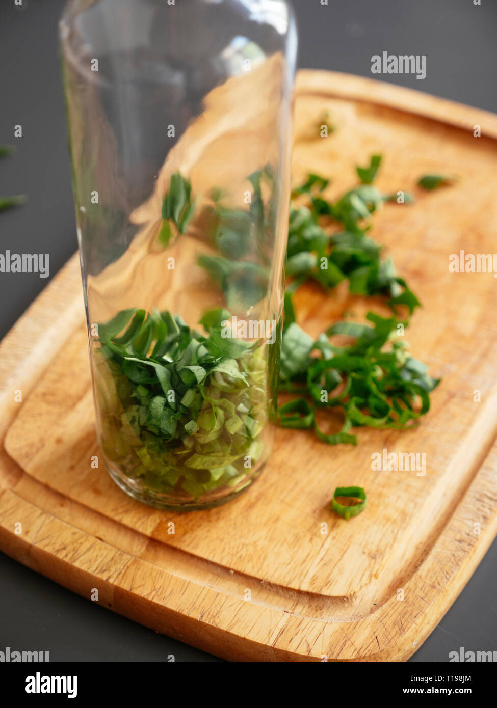 Chopped wild garlic in an empty bottle. Stock Photo