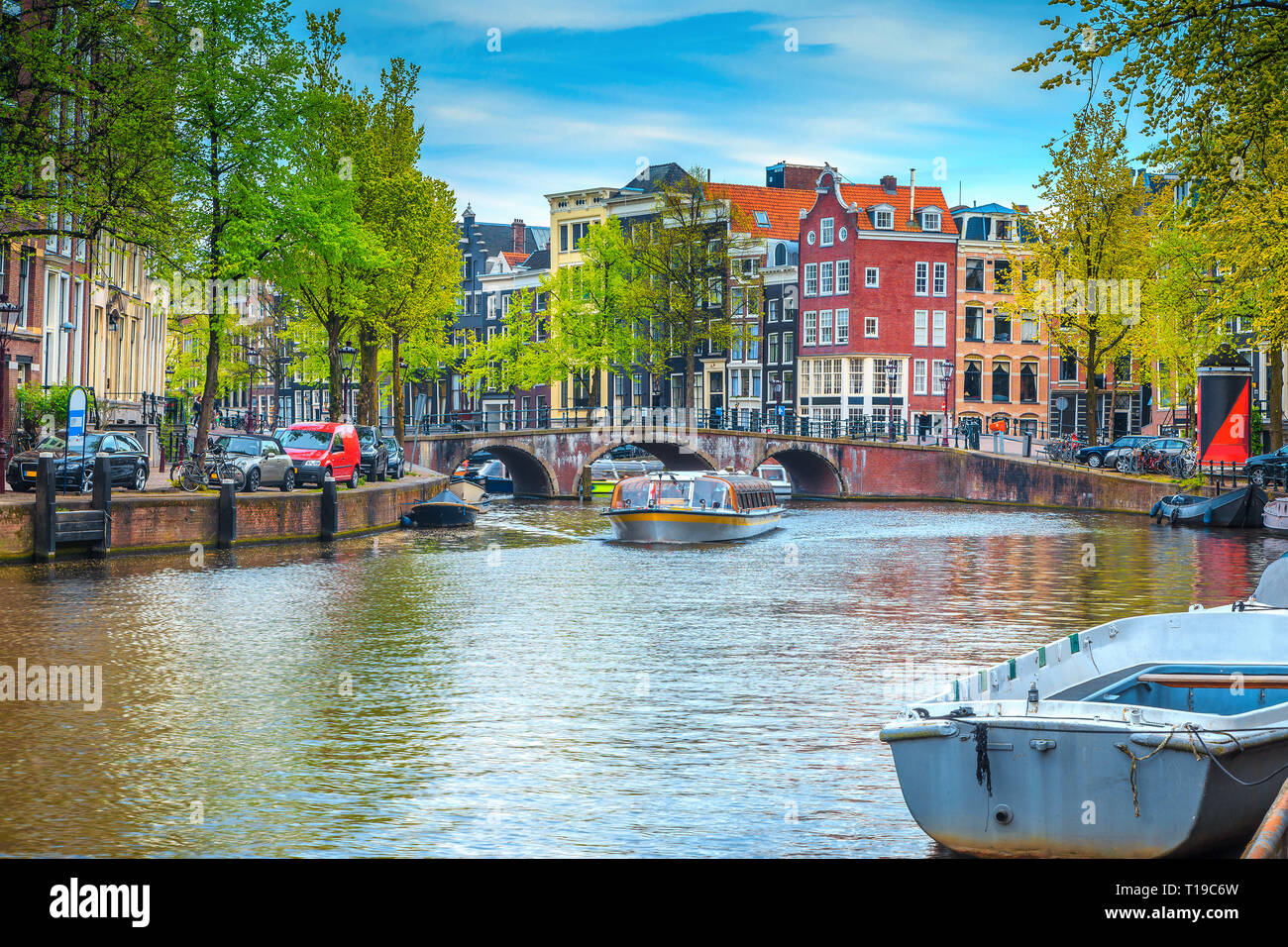 Stunning popular travel and touristic location, fabulous cityscape with traditional dutch houses. Water canal with touristical boats and bridge over t Stock Photo