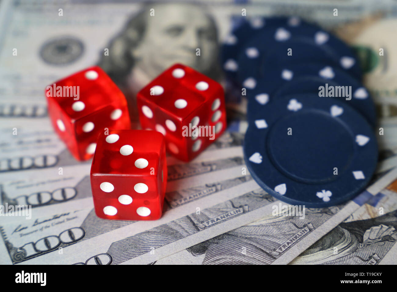 Red dice and casino gaming chips on US dollars bills. Concept of casino games, winning, gambling, luck or randomness Stock Photo