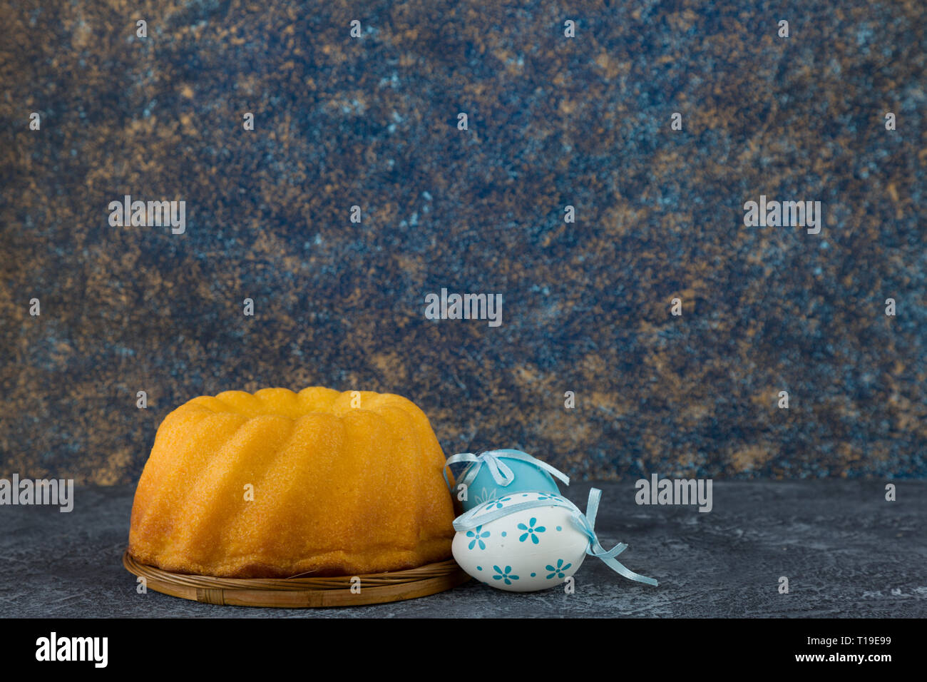 Easter bread and blue Easter eggs on dark stone table Stock Photo