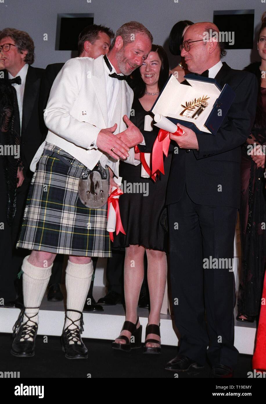 CANNES, FRANCE - May 24, 1998:  Best actor winner PETER MULLAN (left) congratulates Palme D'Or winner THEO ANGELOPOULUS at the Cannes Film Festival. Stock Photo