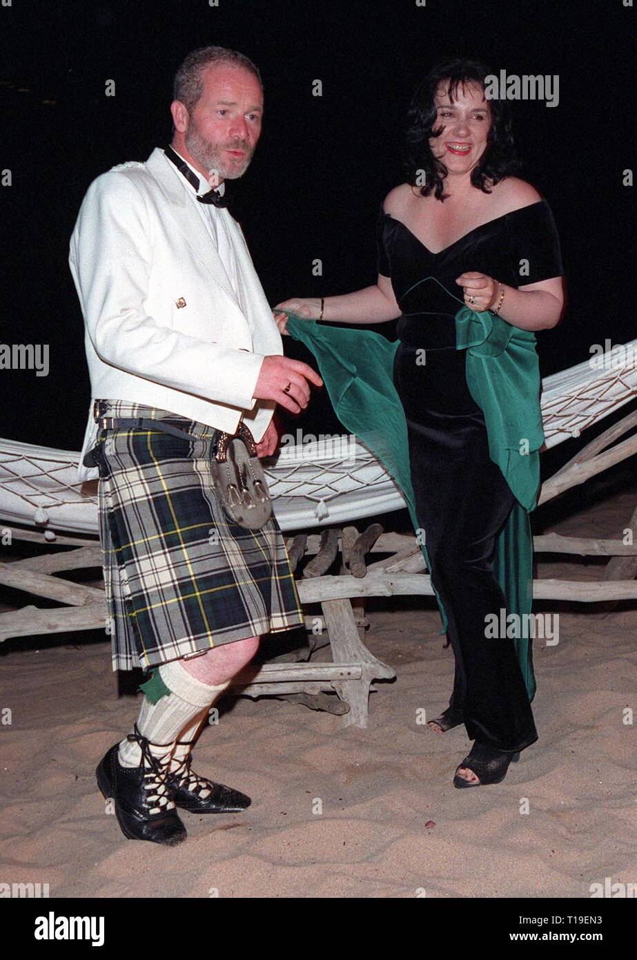 CANNES, FRANCE - May 24, 1998:  Cannes Best Actor winner PETER MULLAN celebrates his award by dancing on the beach with his wife ANNIE. Stock Photo