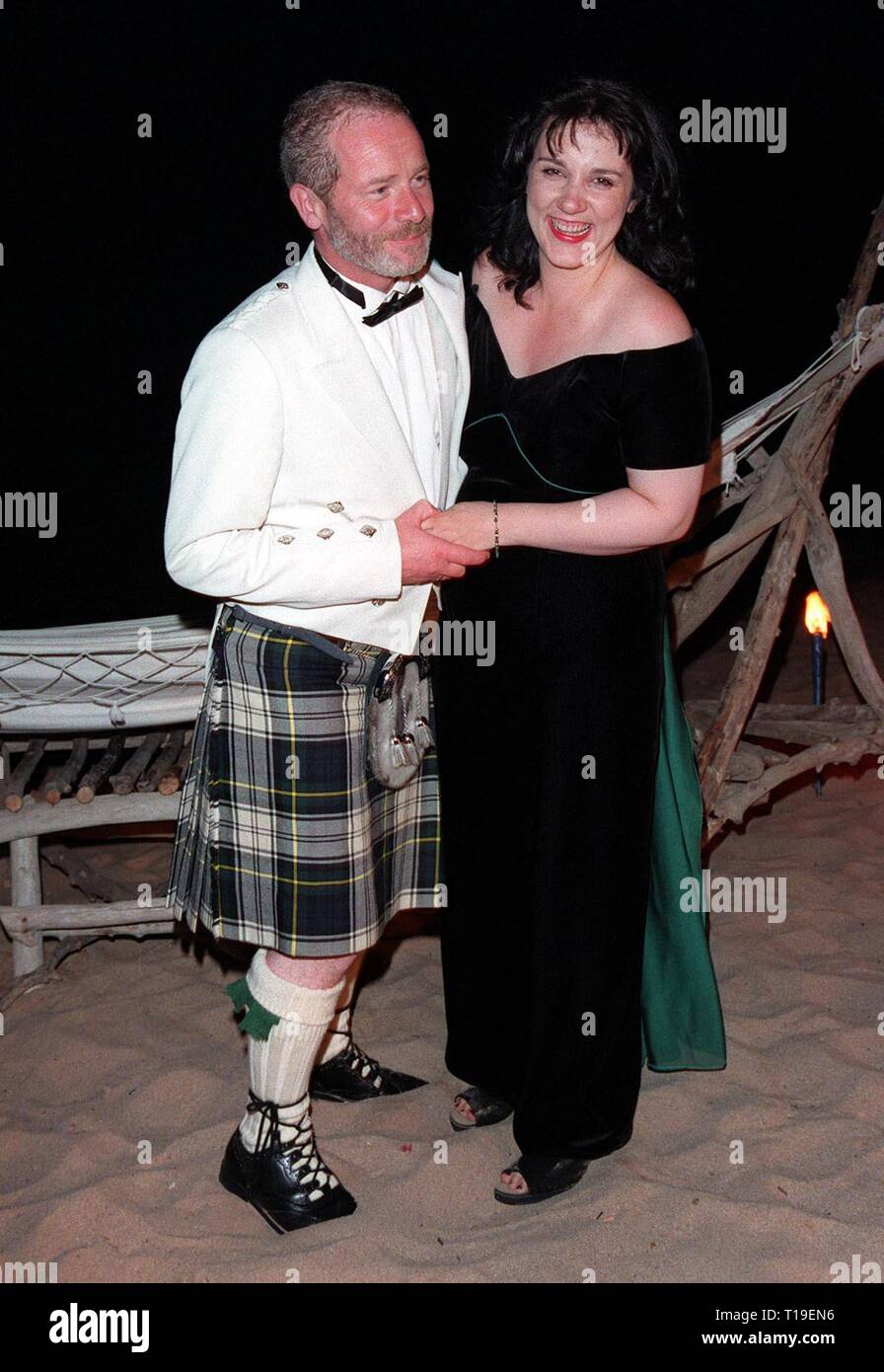 CANNES, FRANCE - May 24, 1998:  Cannes Best Actor winner PETER MULLAN celebrates his award by dancing on the beach with his wife ANNIE. Stock Photo