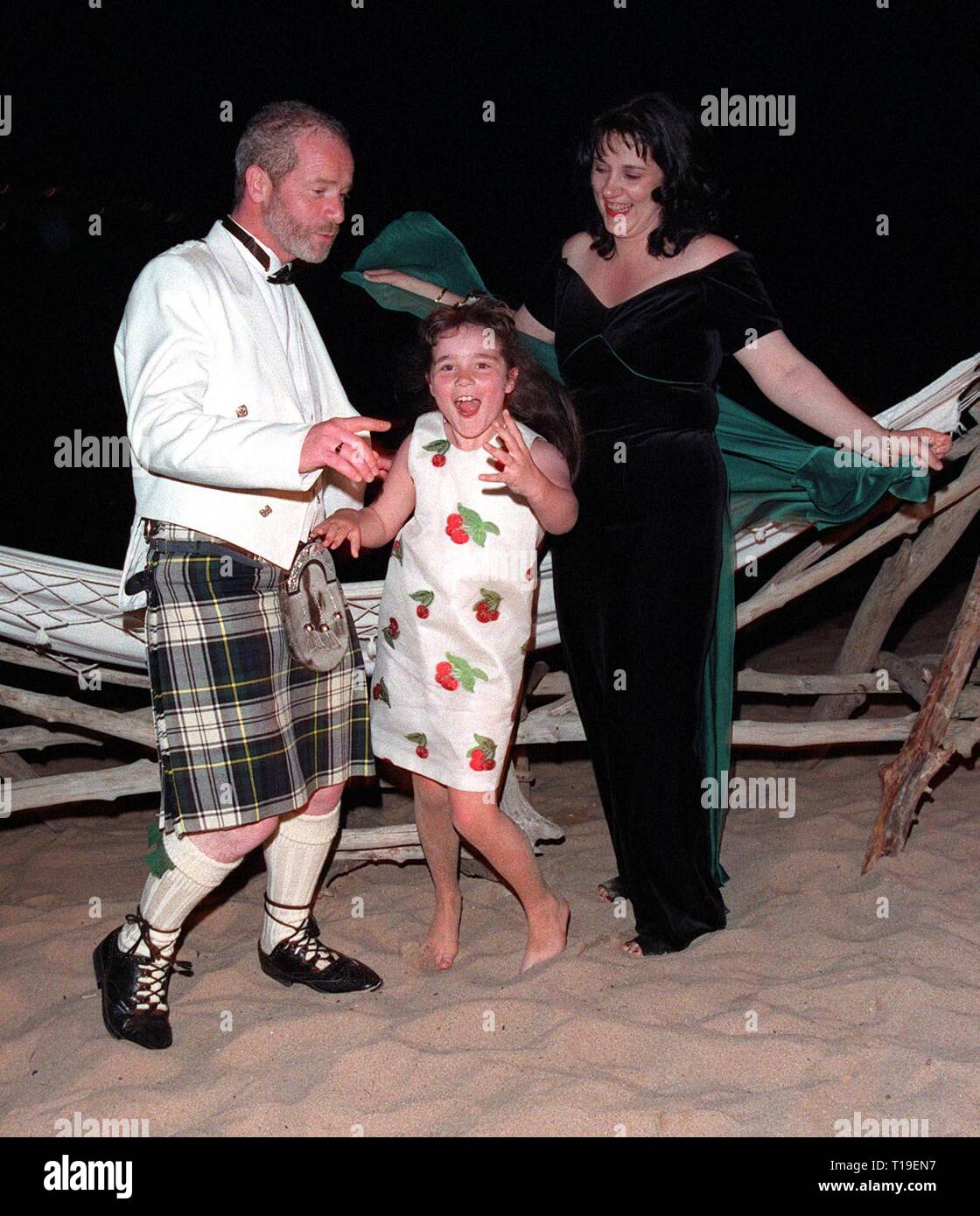 CANNES, FRANCE - May 24, 1998:  Cannes Best Actor winner PETER MULLAN celebrates his award on the beach with his wife ANNIE & daughter MAIRI (age 7). Stock Photo