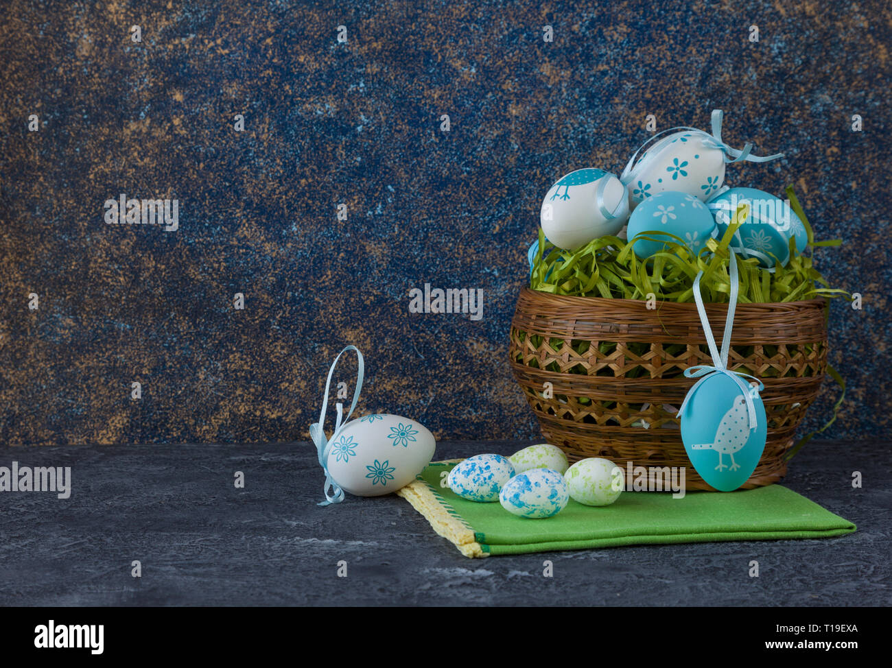 Easter basket with coloured Easter eggs on dark stone table Stock Photo