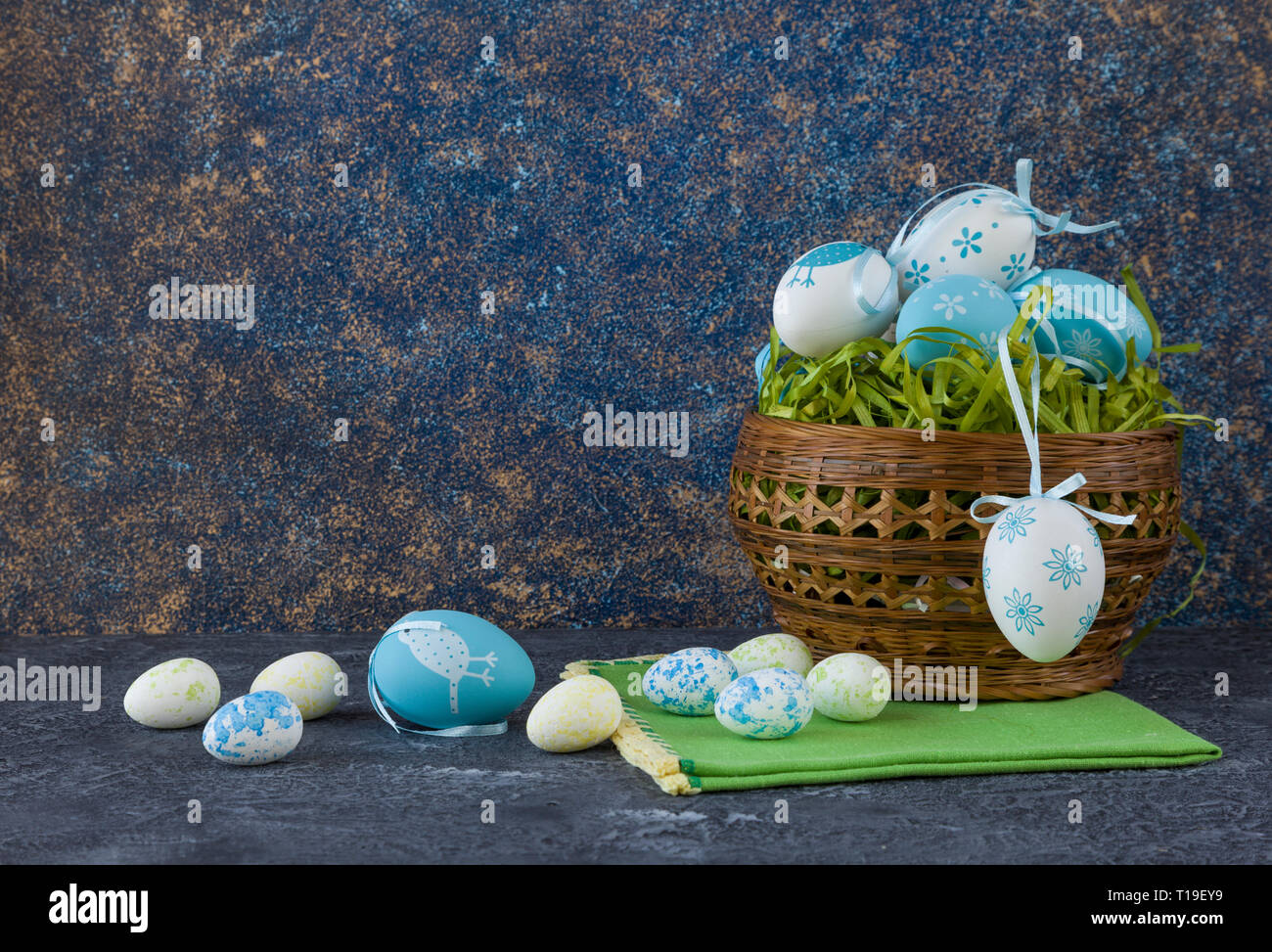 Easter basket with coloured Easter eggs on dark stone table Stock Photo
