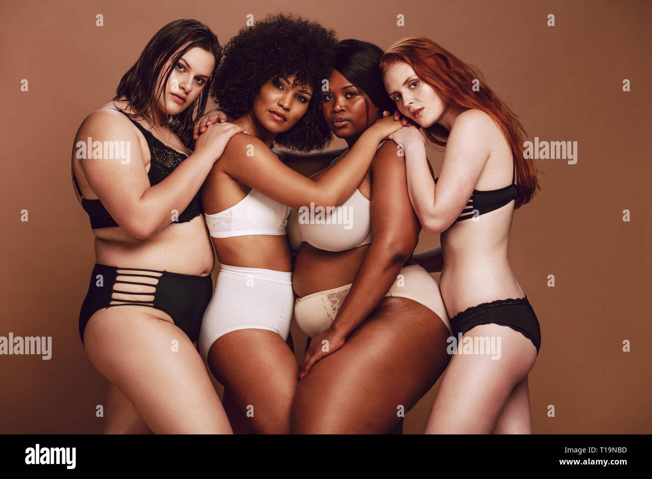 Group of different size women in lingerie hugging each other and looking at  camera. Diverse group of women in different underwear together on brown ba  Stock Photo - Alamy