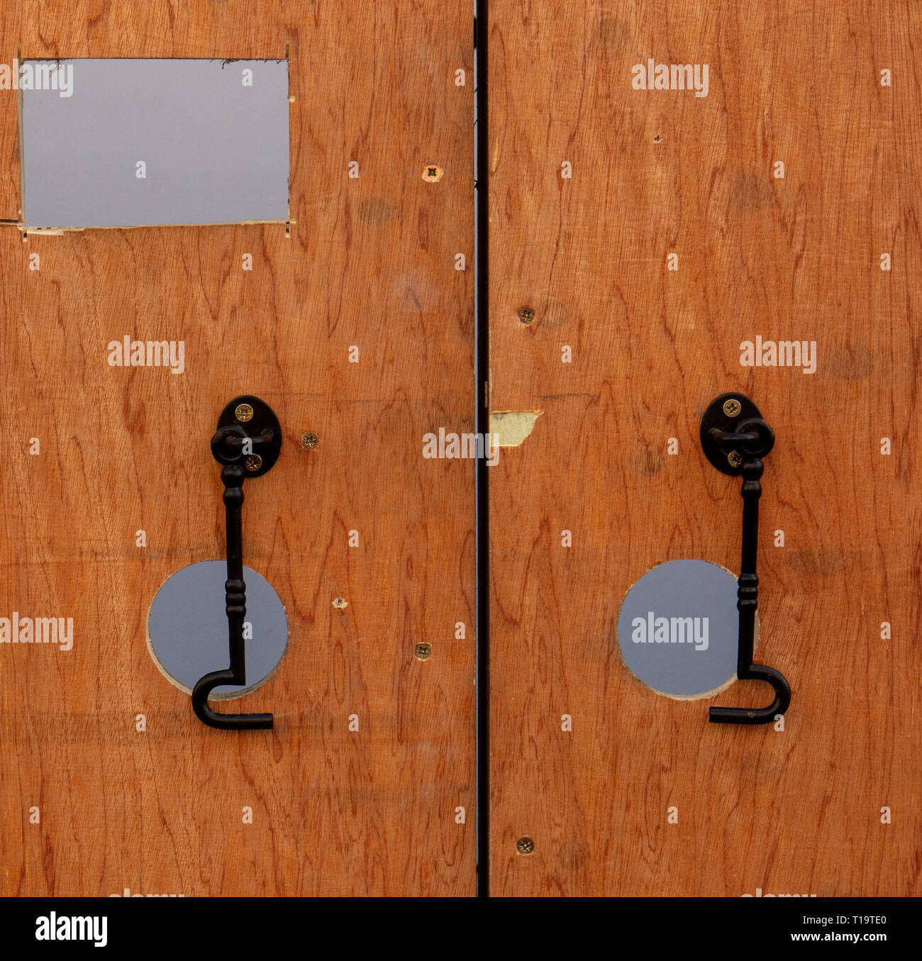Plywood doors with locks and holes in a wooden temporary structure that
