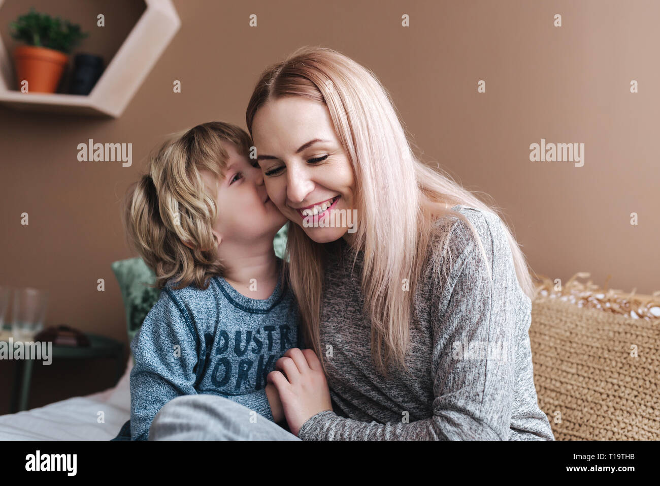 Son is kissing his mother. Mom and son. Happy mother's day. Mother hugging her child at home Stock Photo