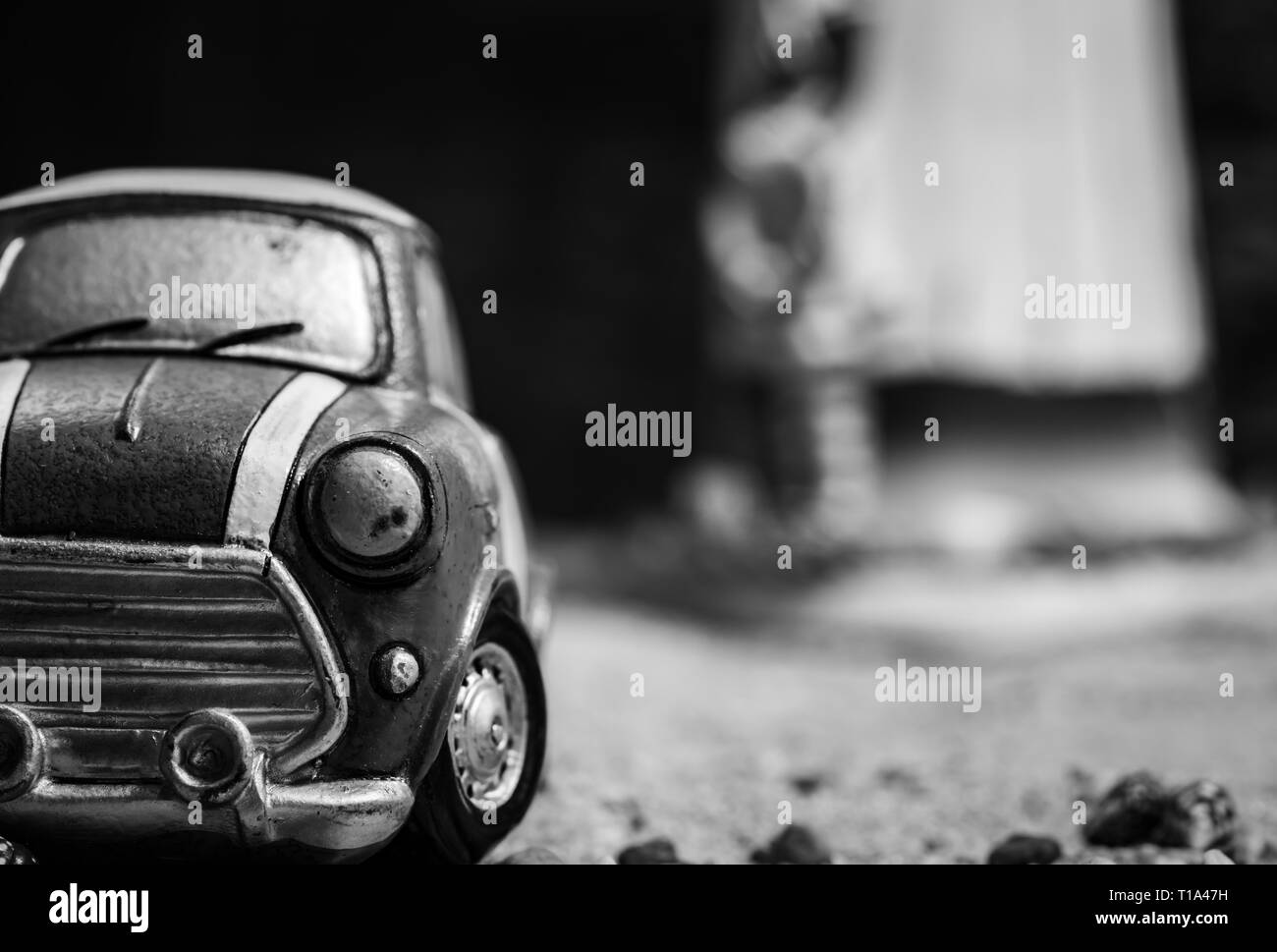 Front View Of Small Car Toy Model On Sand Road Black And White