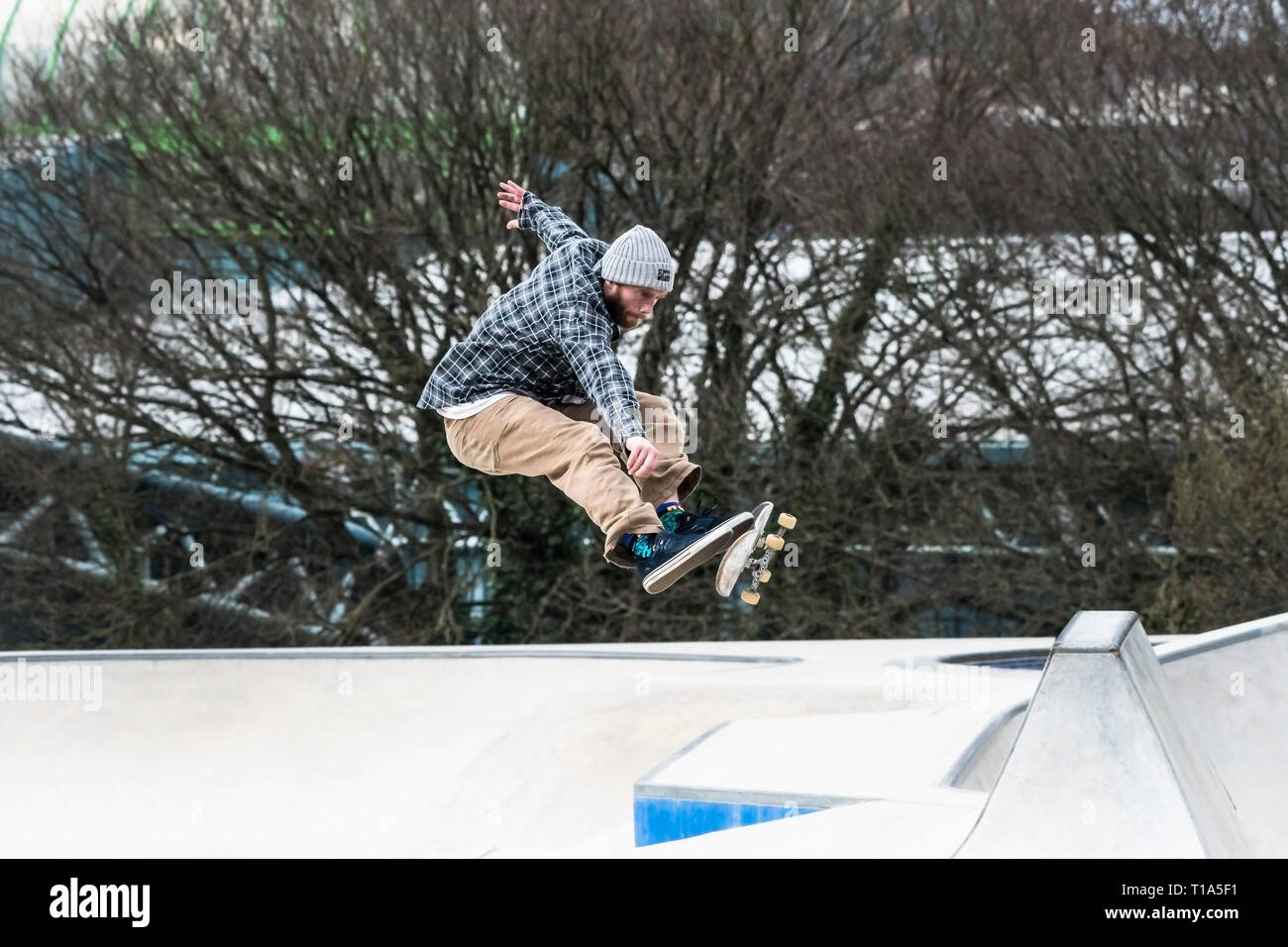 A skateboarder performing an aerial trick at Concrete Waves in Newquay in Cornwall. Stock Photo