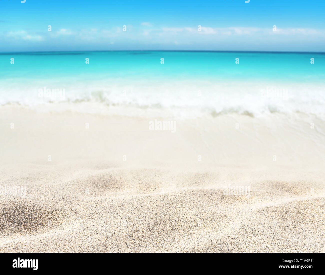 Beach blurred background. Tropical island paradise. Sandy shore washing by the wave. Bright turquoise ocean water.  Dreams summer vacations destinatio Stock Photo
