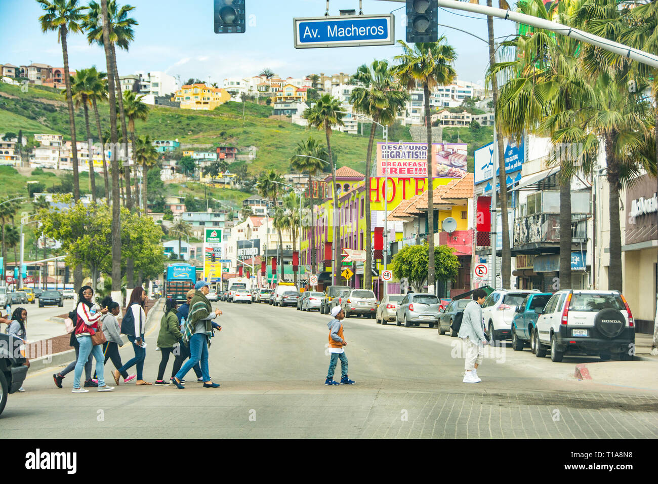 A group of Mexican's walking to the other side of the street on a red light, Ensenada, Mexico. Stock Photo