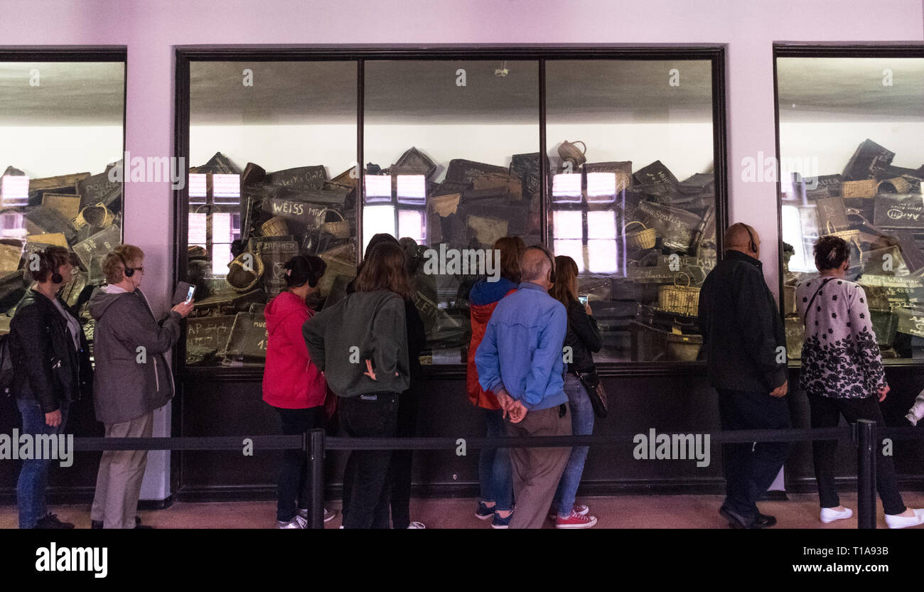 Oswiencim, Poland - September 21, 2019: Tourists take part in a guided tour inside the Auschwitz buildings, in a gallery with the belongings of the Stock Photo