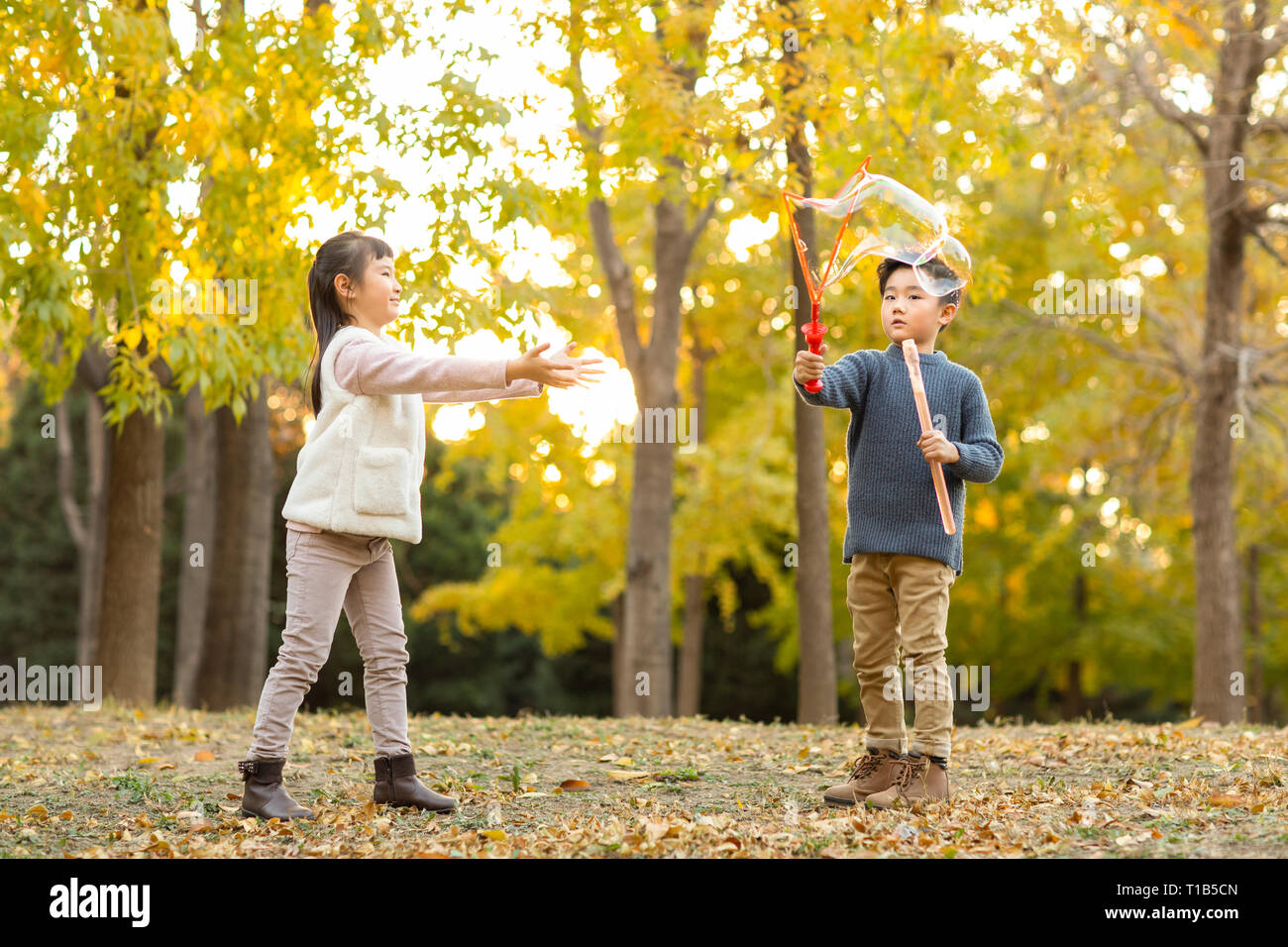 Two children playing with bubbles Stock Photo - Alamy