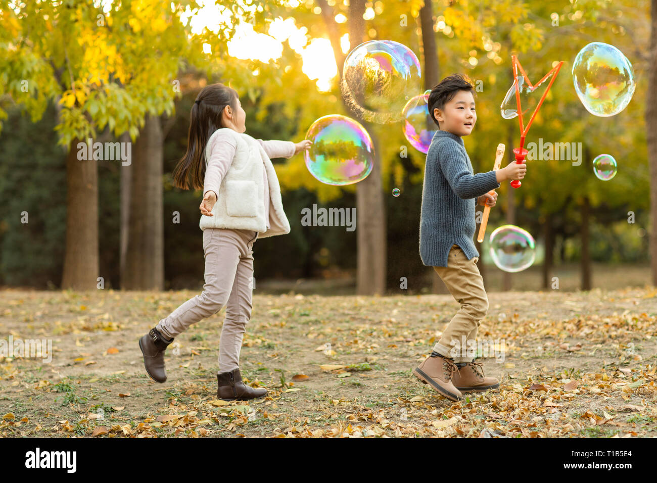 Two children playing with bubbles Stock Photo - Alamy