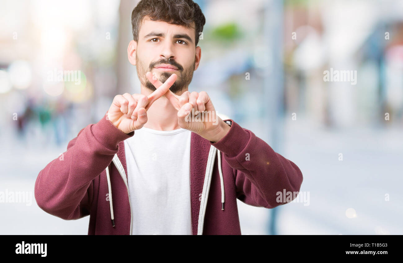 Young handsome man over isolated background Rejection expression ...