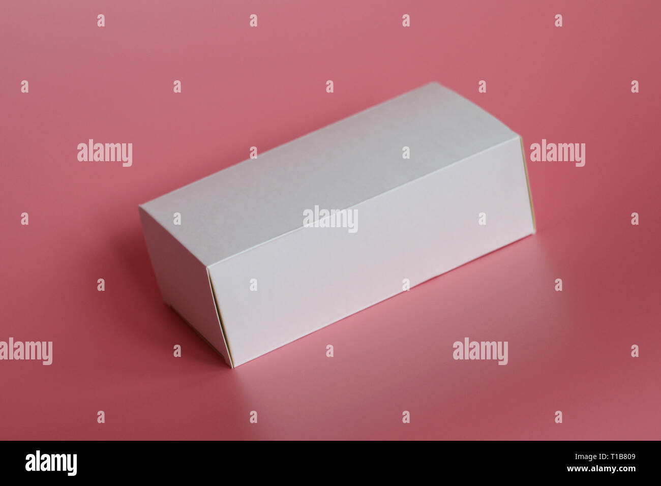 White box lies on a pink background. Horizontal white box. Pink ...