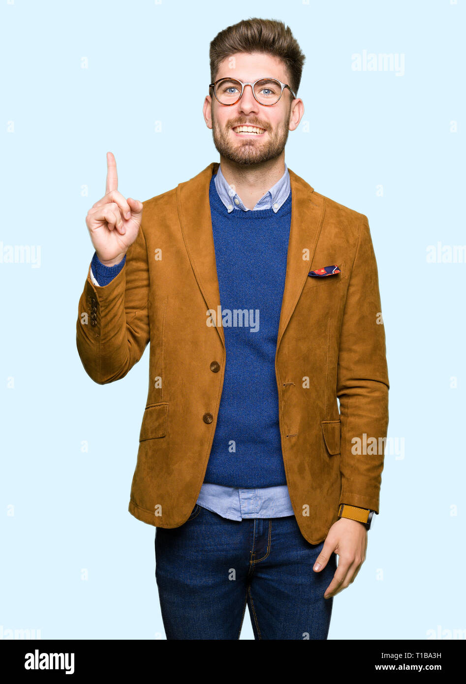 Young handsome business man wearing glasses pointing finger up with ...