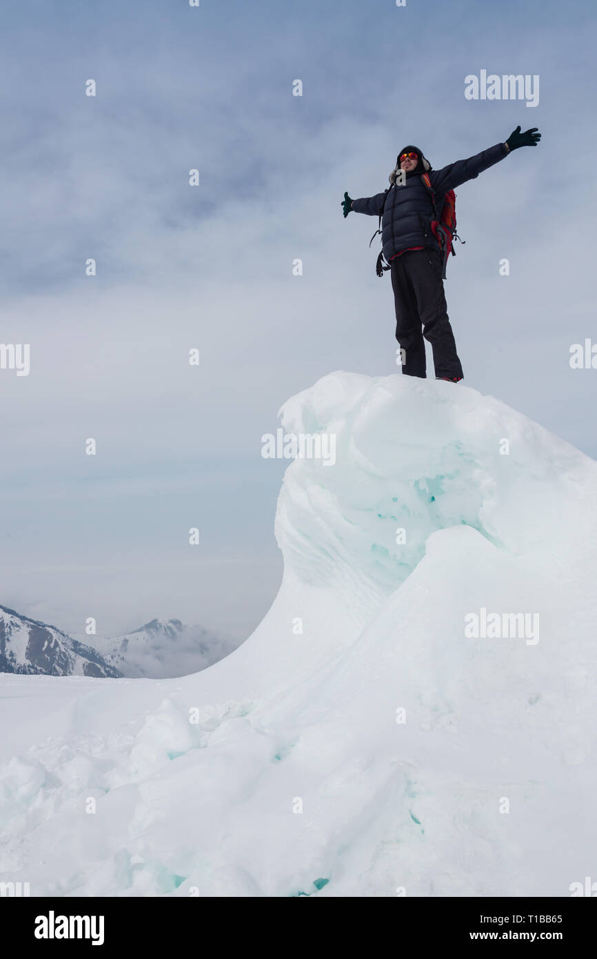 Extreme winter sports: climber reaches the top of a snowy peak in the ...