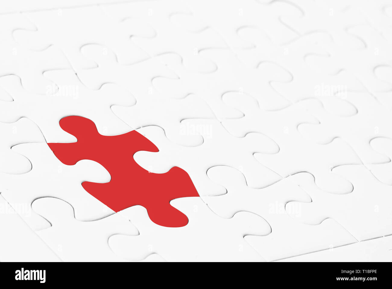 Leadership or thinking different concept. Close up red jigsaw puzzle in the midst of white. Depicts special person with a thought that is a leader And Stock Photo