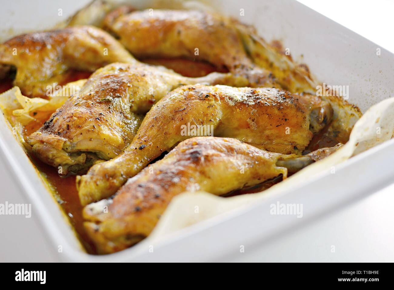 Close Up of a Roasted Chicken Drumsticks in a Roasting Pan. Stock Photo