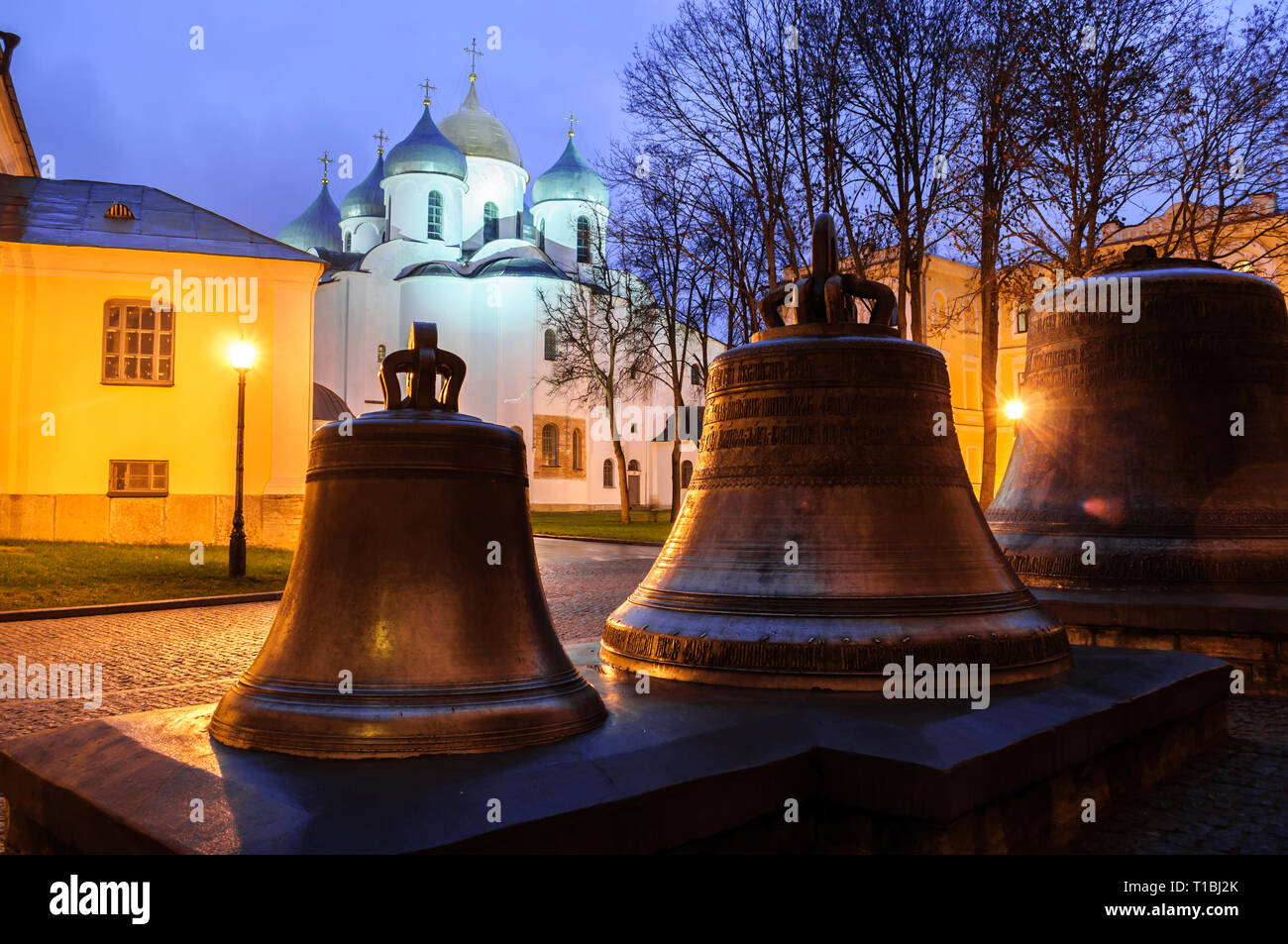 Night landscape - St Sophia cathedral and veche bells on the pedestal in Veliky Novgorod Kremlin park in autumn night in Veliky Novgorod, Russia. Land Stock Photo