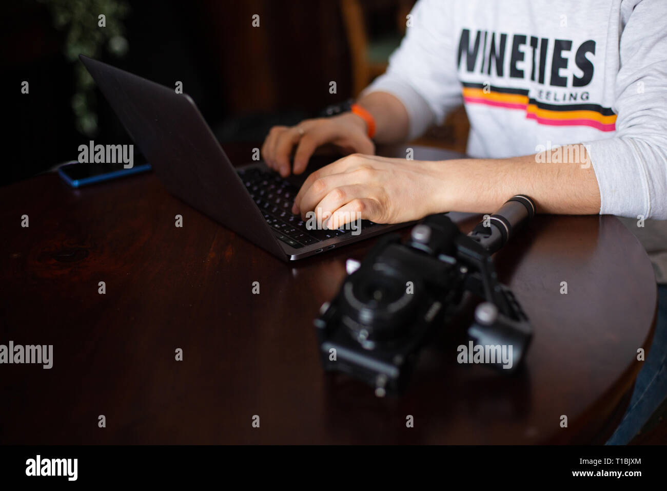 Hands of man videographer or blogger with laptop and camera Stock Photo