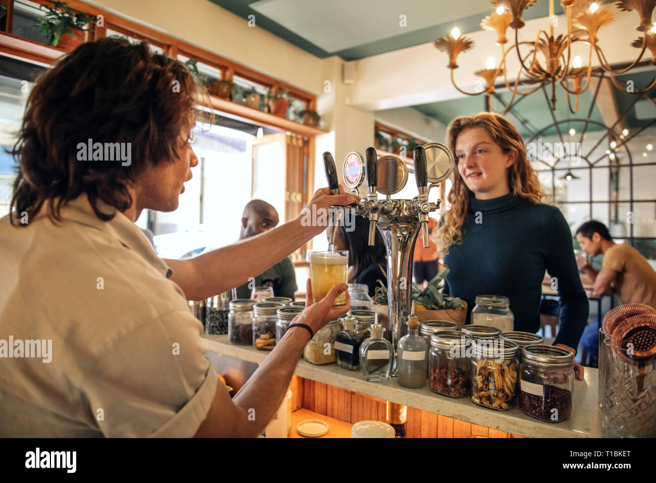 Smiling young woman ordering drinks in a pub Stock Photo