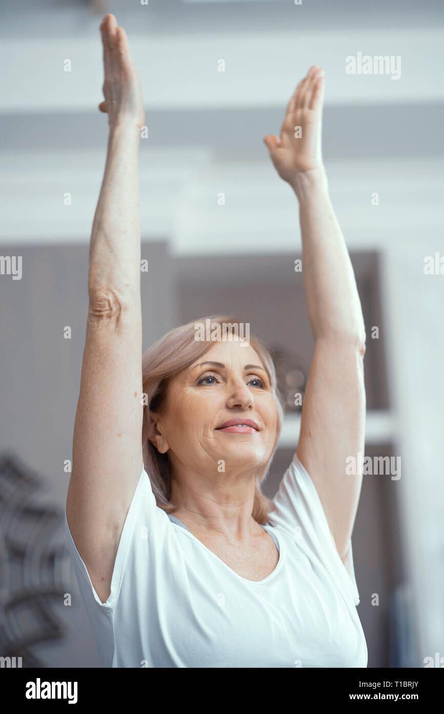 Beautiful Woman Over 50 Years Old Likes to Do Yoga at Home Stock Photo